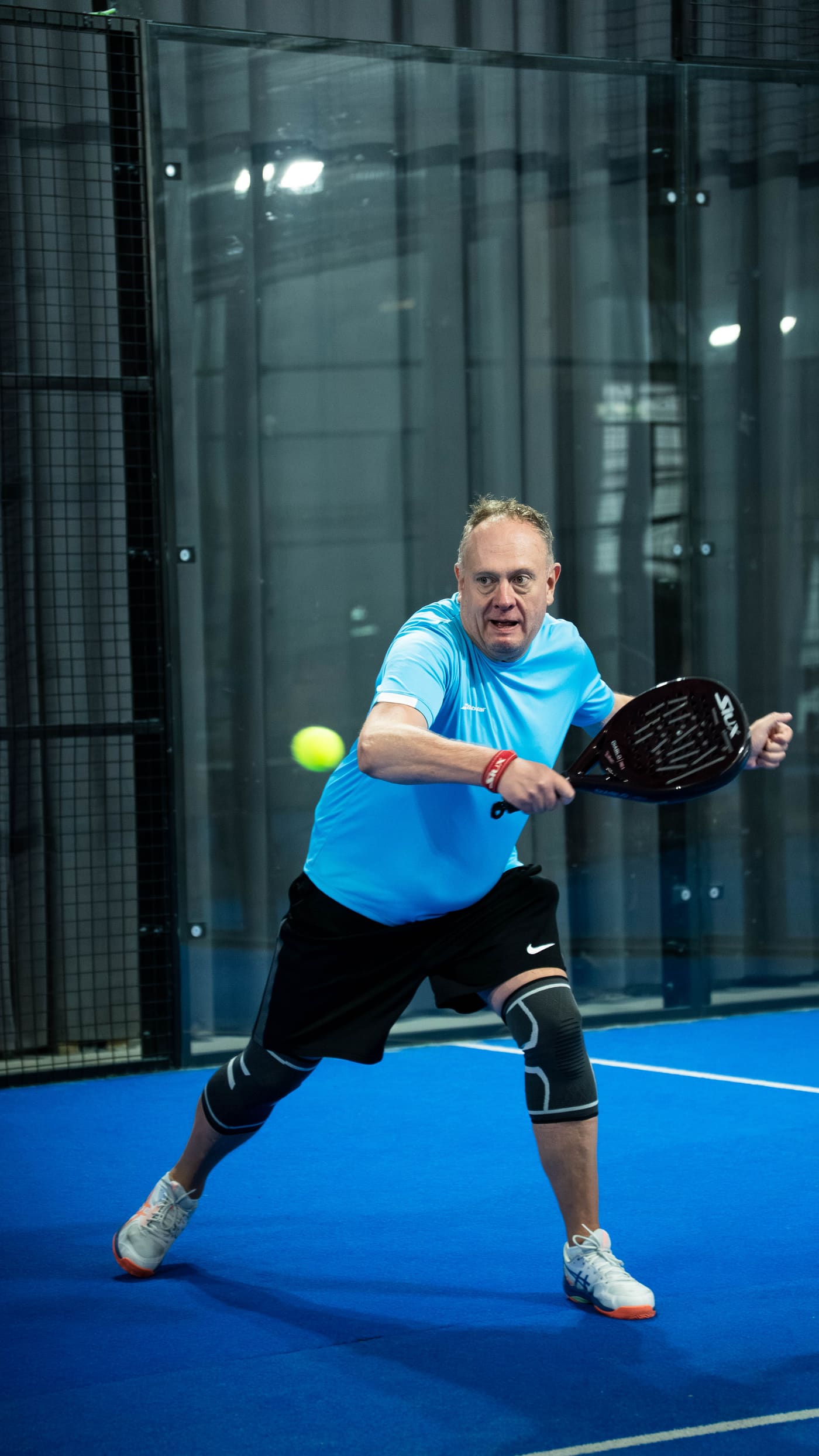 Spiller returnerer ballen med padelracket hos Bærum Padel