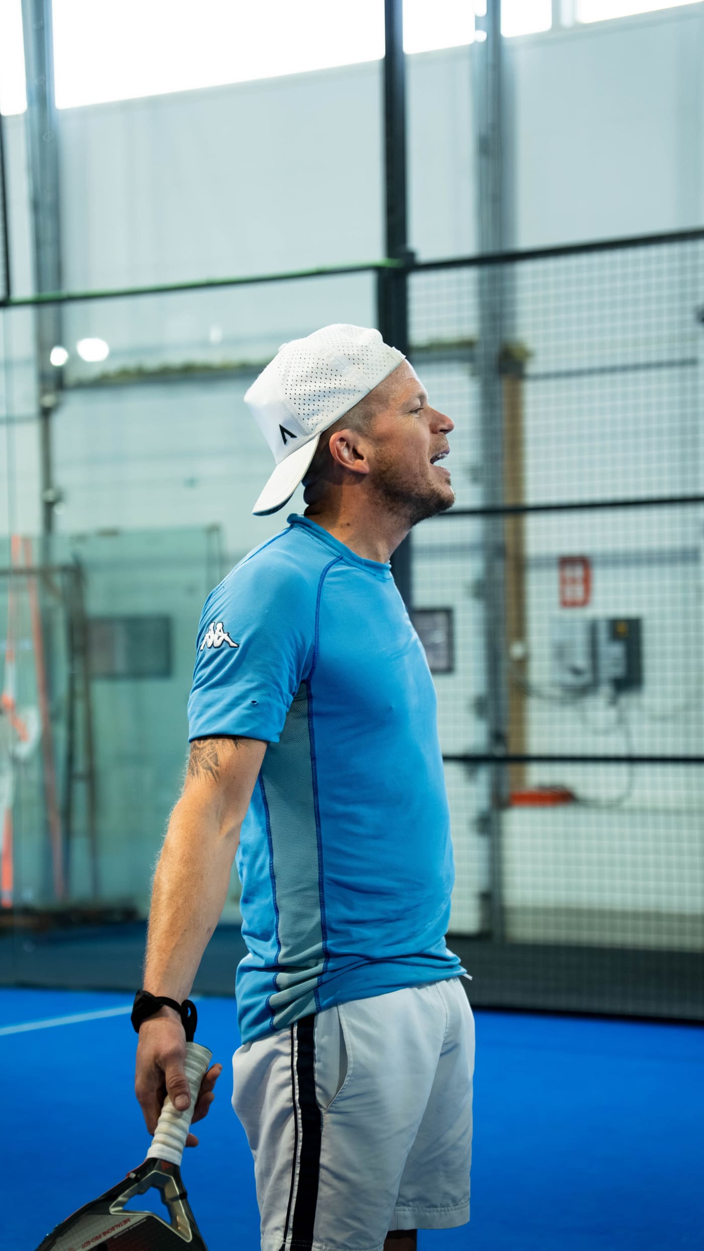 Spiller i blå skjorte klar på padelbanen hos Bærum Padel