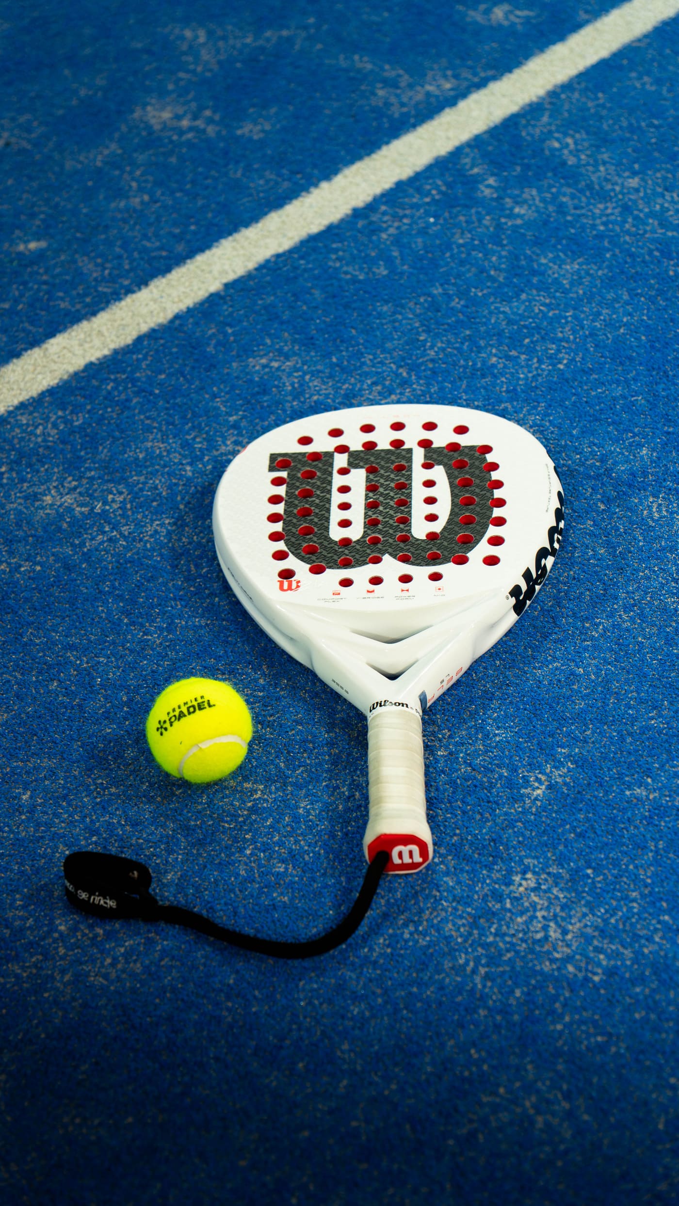 Padelracket og ball på den blå banen hos Bærum Padel