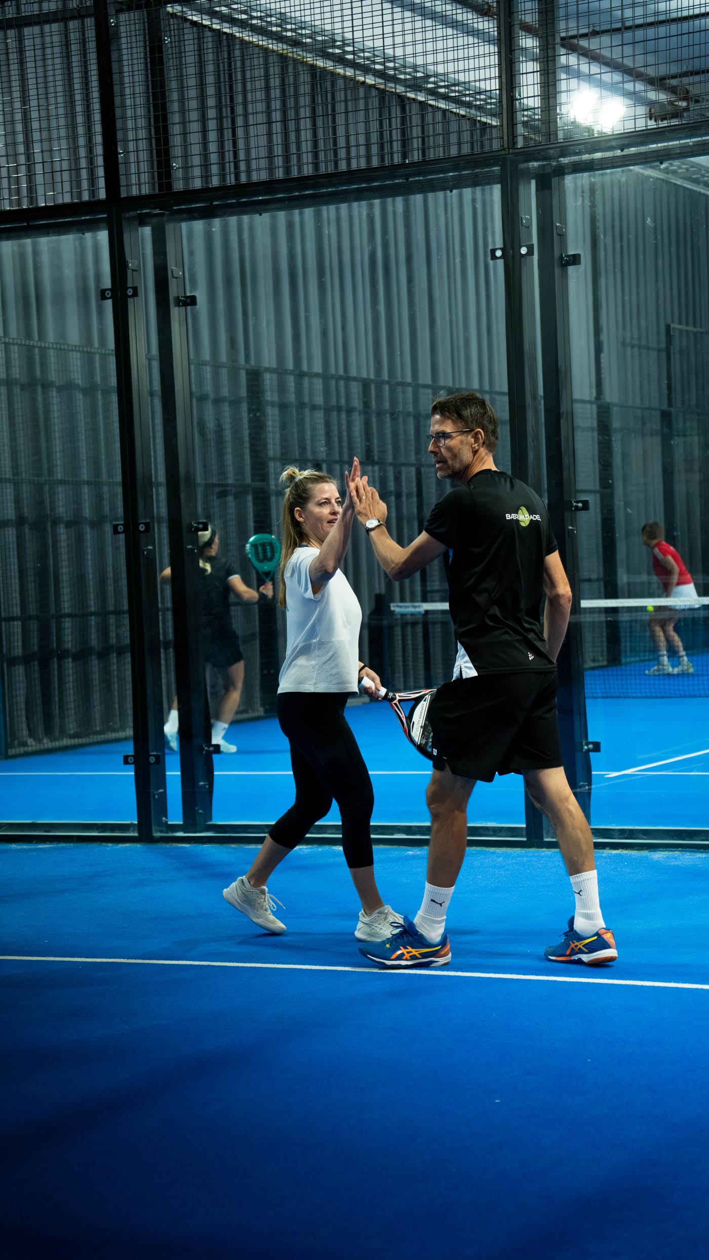 To spillere gir high five på banen hos Bærum Padel
