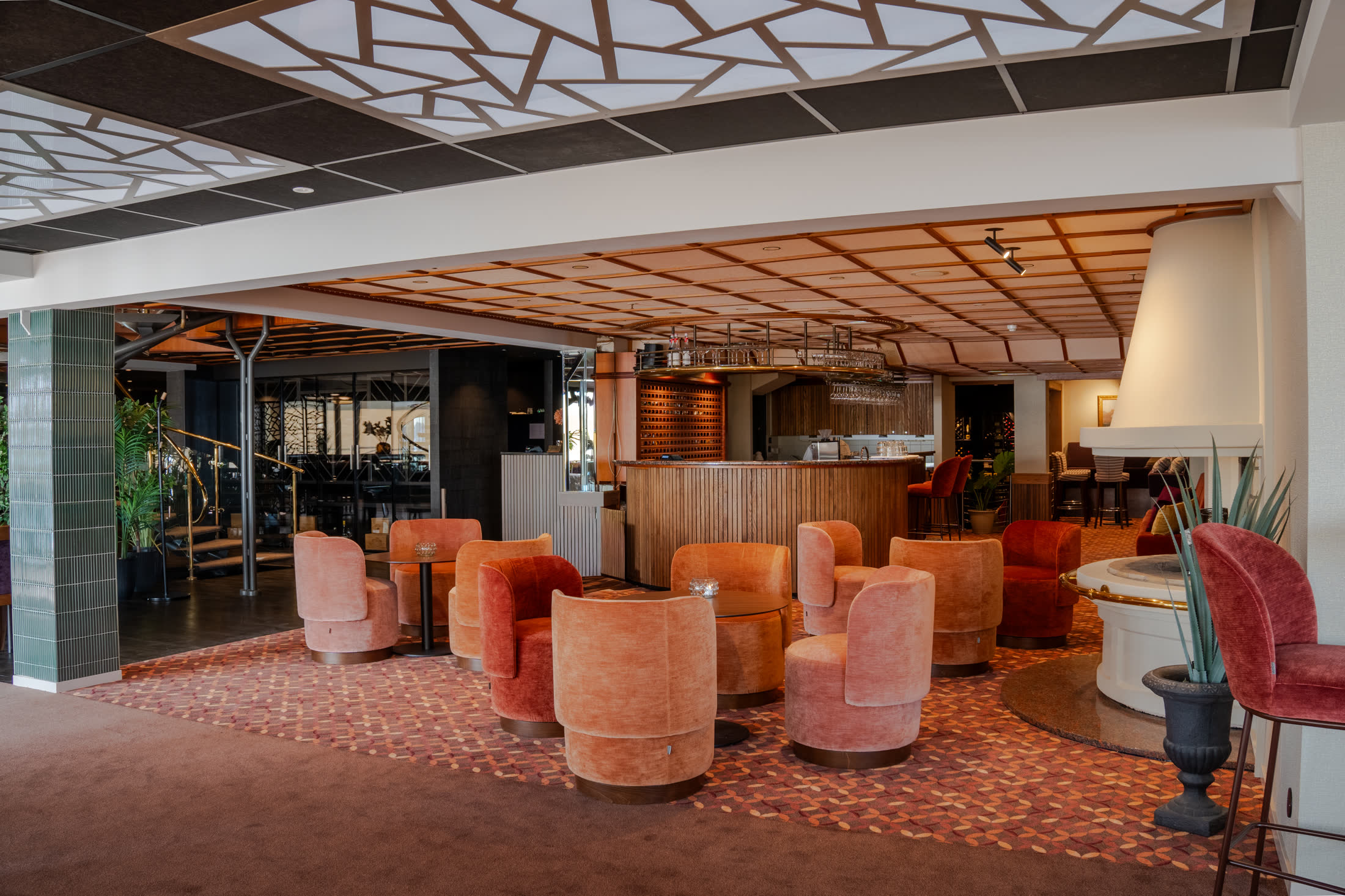 Barområdet på Holmen Fjord Hotel med rosa fløyelsstoler rundt runde bord