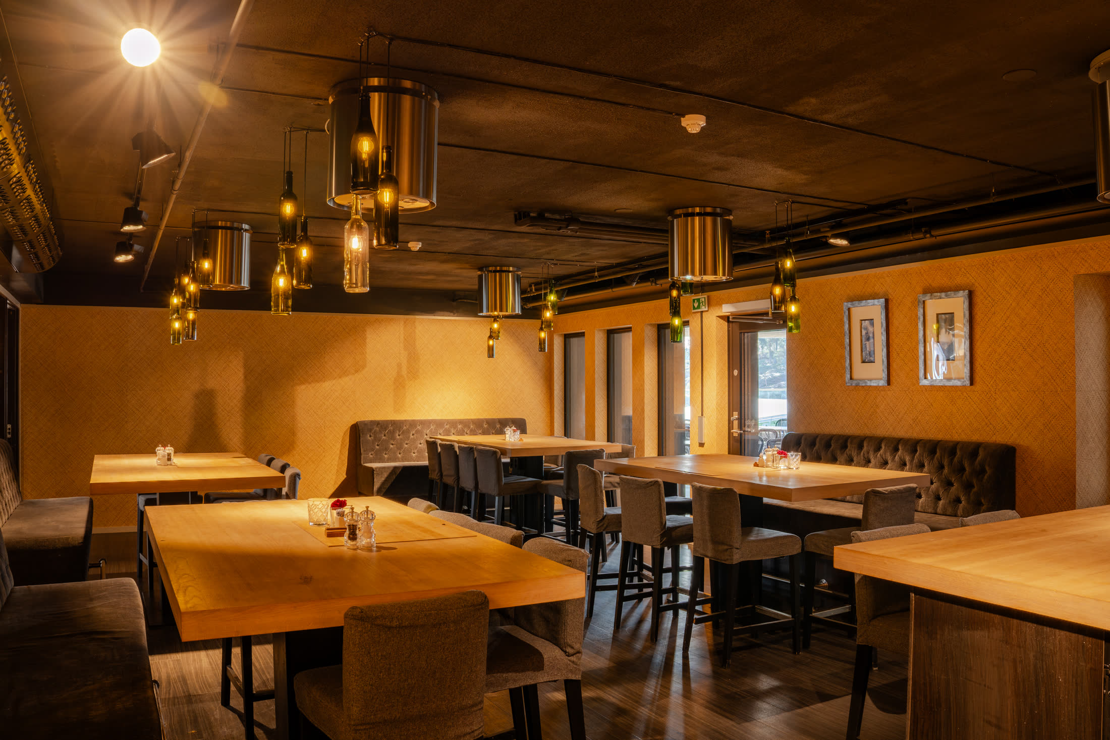 Bistroavdeling med malerier på veggen og trebord