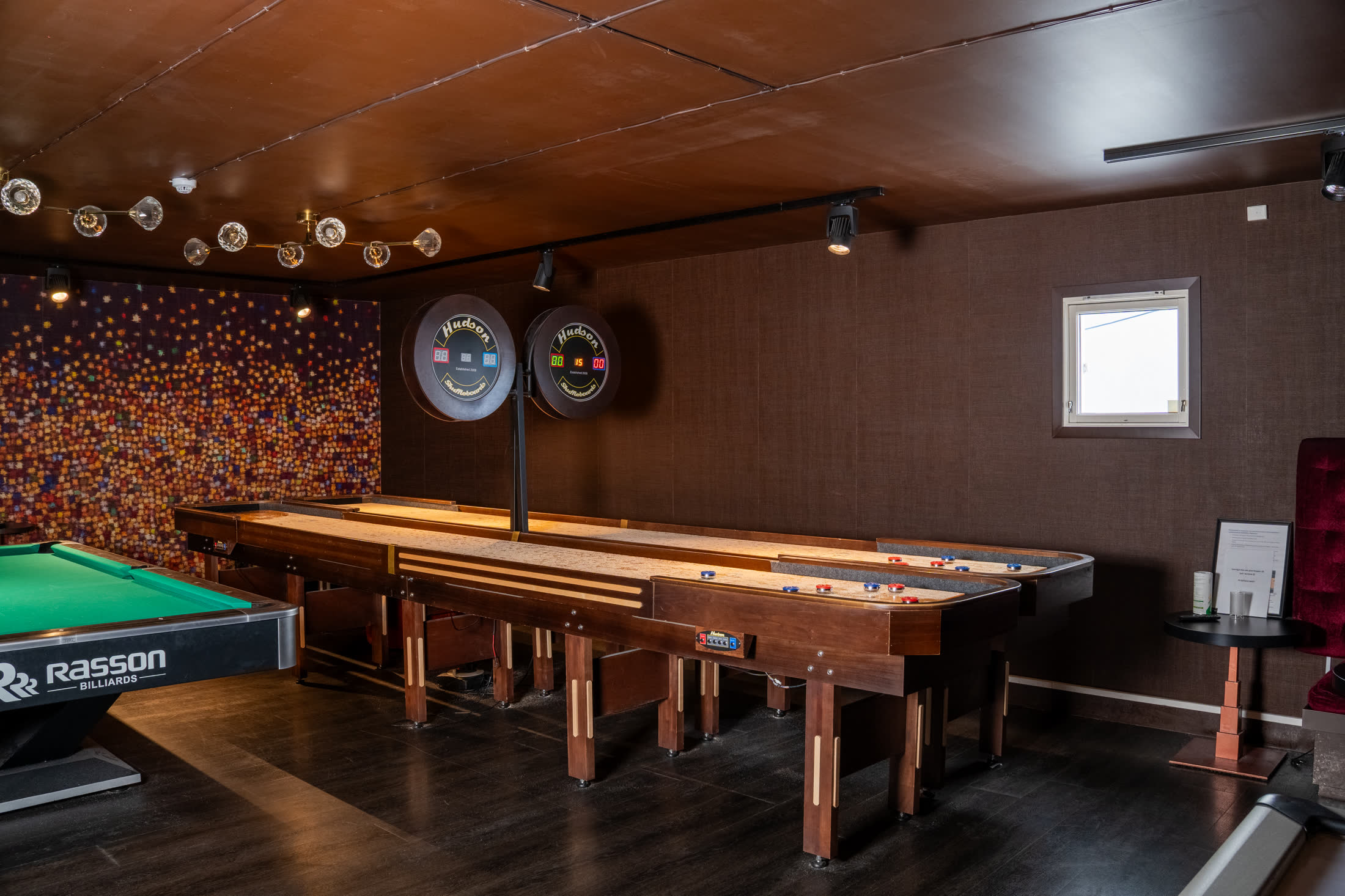 Spillerom med biljardbord, shuffleboard og fargerik veggdekor