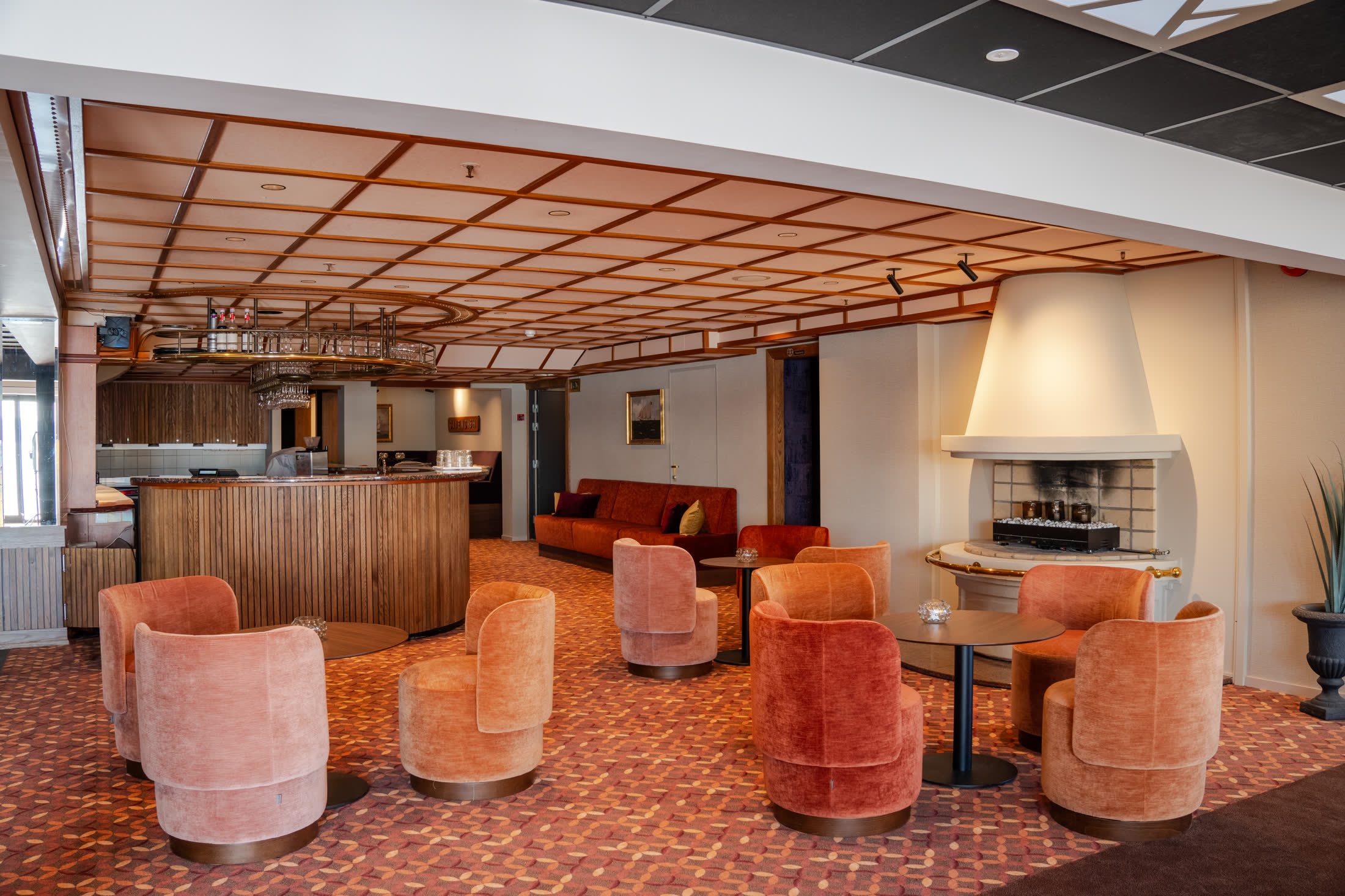 Loungeområde med peis og fløyelsstoler på Holmen Fjord Hotel